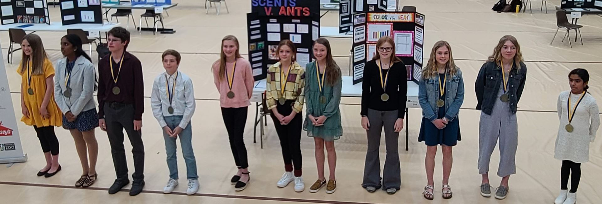 photo 11 sixth to eight grade students posing for photo with medals won for being the Nebraska state science fair junior high 2022 winners  